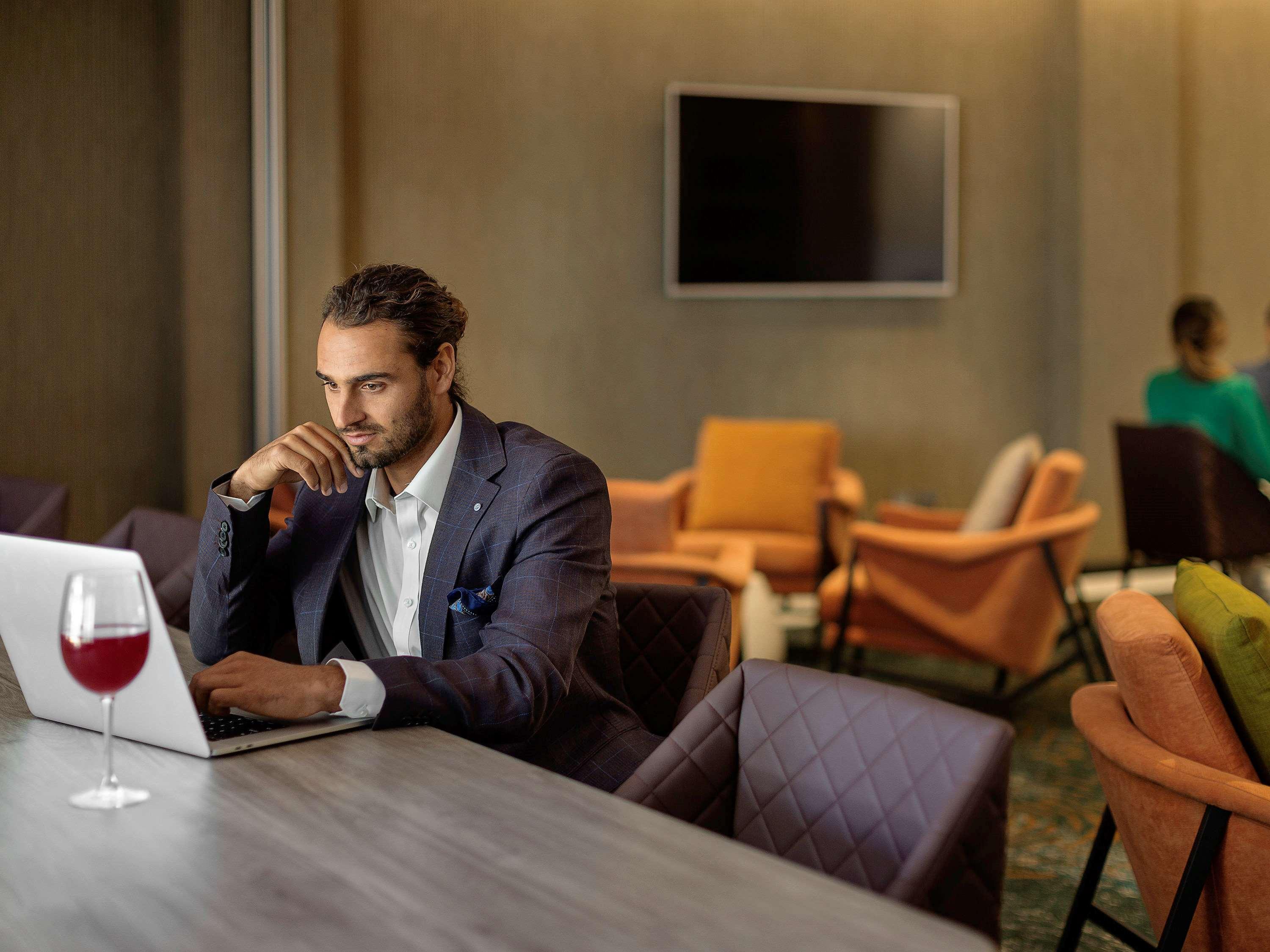 พูลแมน โรโตรัว Hotel ภายนอก รูปภาพ A man working on a laptop